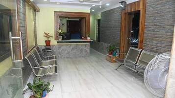 A reception area with a marble counter, metal chairs, and potted plants.