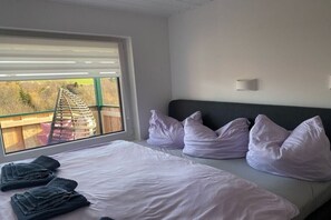 A bedroom with a bed, pillows, a window with a view of a wooden structure outside. - Holiday home in the Harz Mountains with 2 bedrooms (Harzgerode OT Güntersberge)