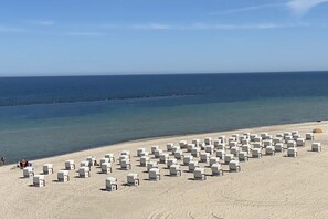 A beach with numerous white beach chairs arranged in rows. - Villa Lena Apt. 7, Nagel Family (Sellin)