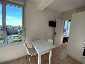 Cuina petita i moderna amb armaris blancs i terra de rajoles.