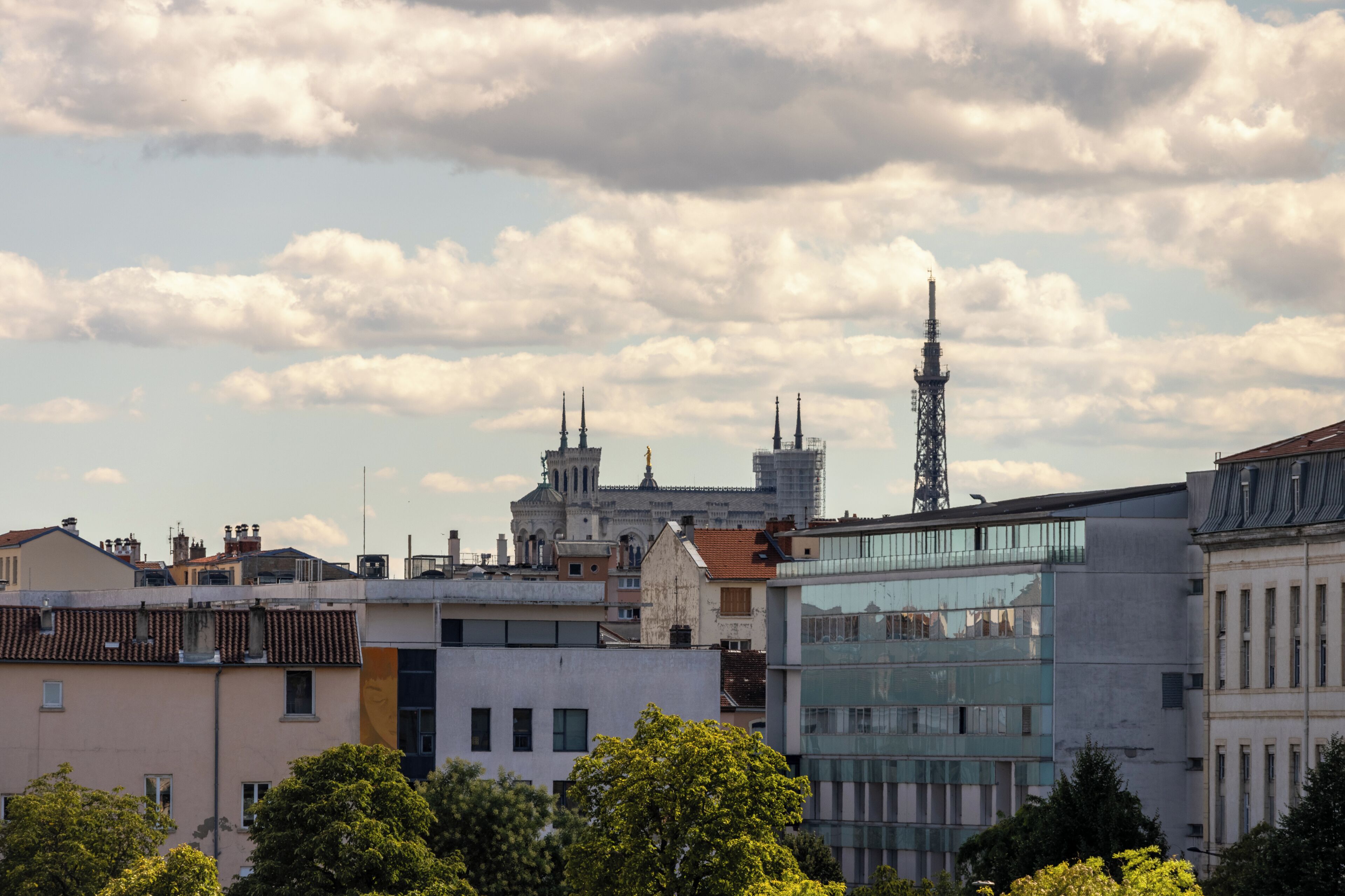 Un paysage urbain avec des bâtiments modernes, une église à deux tours et une tour de communication.