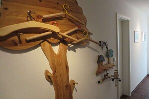 Eine Wandgestaltung aus Holz mit verschiedenen Haken und einem Kleiderhaken.