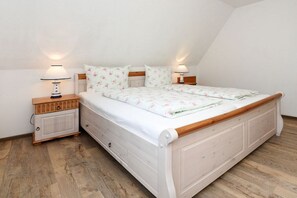 Een slaapkamer met een eenpersoonsbed, twee nachtkastjes en een bedbank.