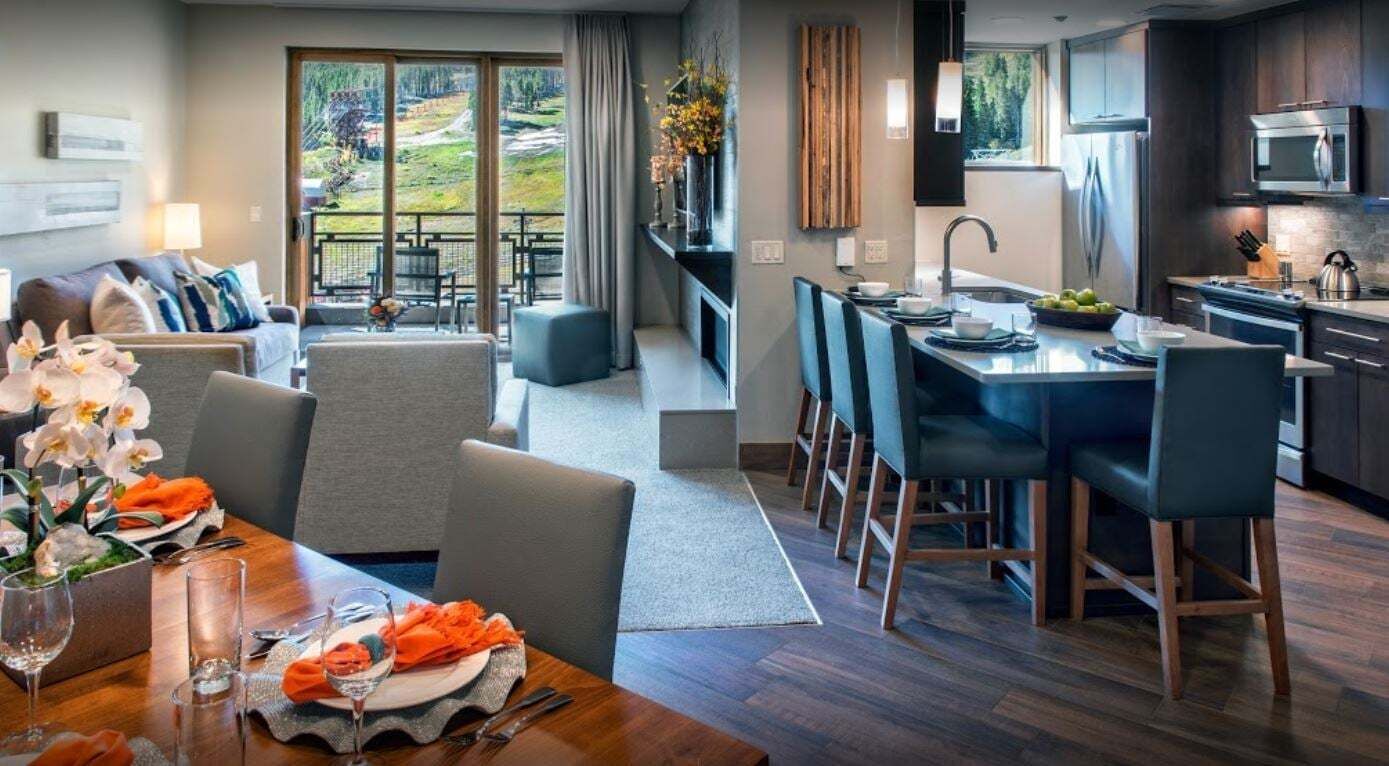 Une chambre d’hôtel moderne dotée d’un coin repas, d’une cuisine et d’un balcon offrant une vue panoramique.