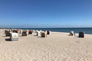 Ein Strand mit zahlreichen Grabsteinen, die in Reihen angeordnet sind.