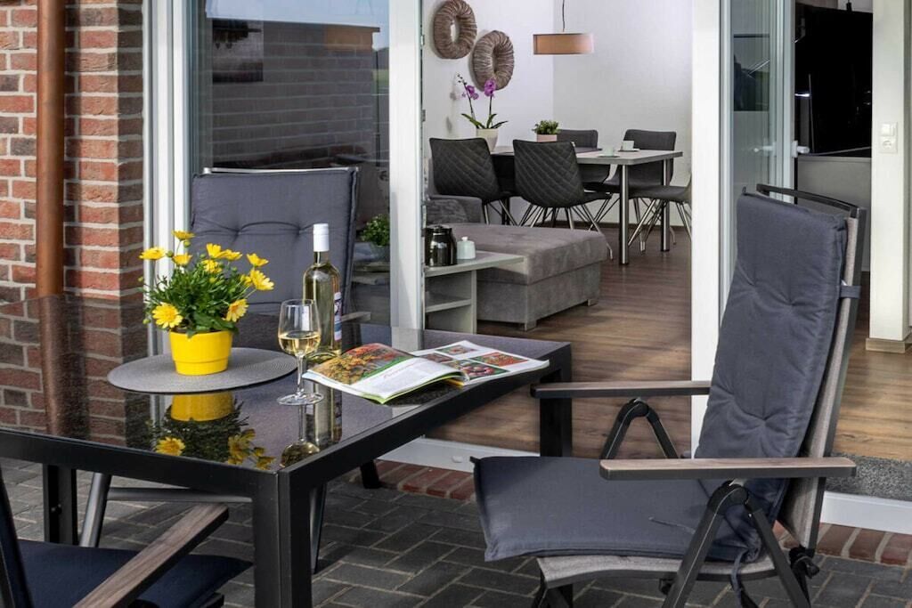 Un salon moderne avec une table en verre, un canapé et un coin repas comprenant des chaises et une table.