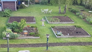Un jardín con jardineras elevadas, una fuente y mobiliario de exterior.
