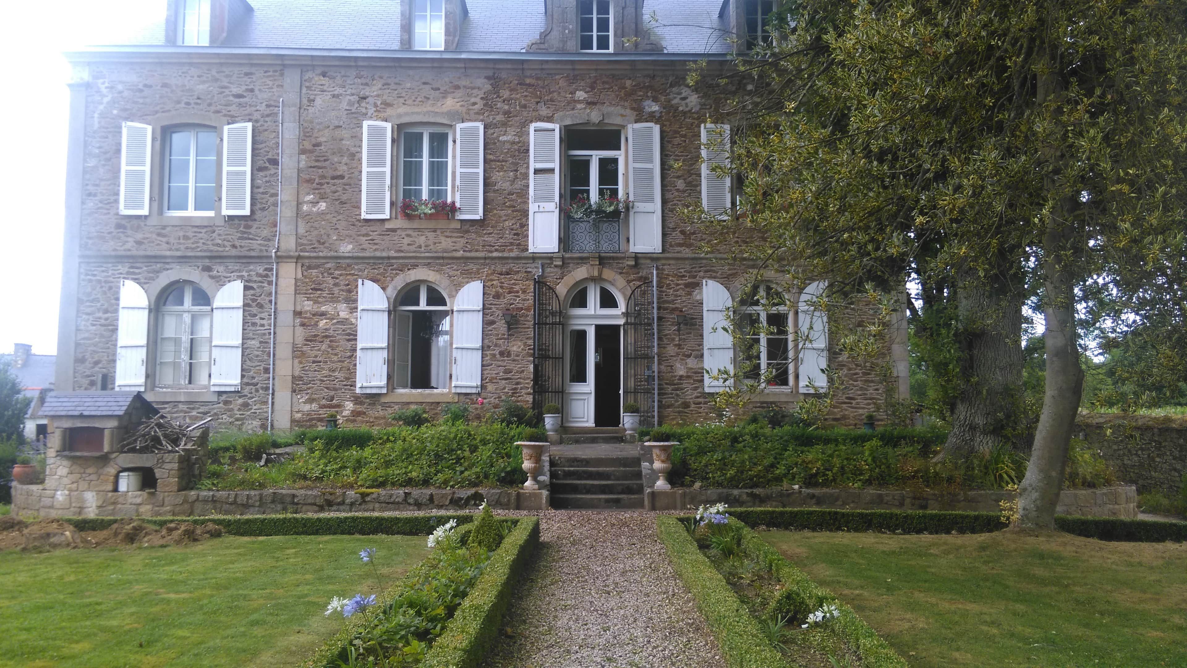 Un bâtiment en pierre doté de nombreuses fenêtres et d’une entrée centrale.