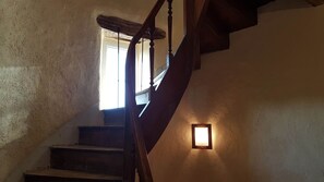 Un escalier en bois, doté d’une rampe, menant à un palier.
