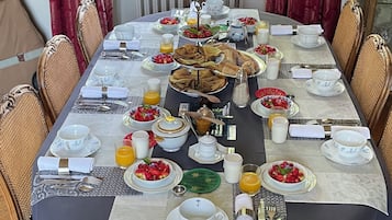 Een ontbijttafel, gedekt met diverse gerechten en dranken.
