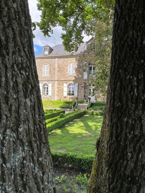 A stone building with arched windows and a well-maintained garden. - The Manor of Bigotière (Pleslin-Trigavou)