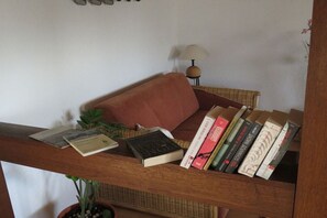 A bookshelf with books and a potted plant. - Holiday apartment with 2 bedrooms (Rüdesheim am Rhein)