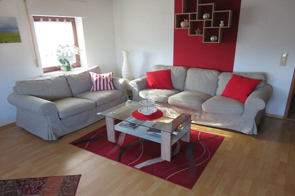 A living room with two sofas, a coffee table, and a red rug.