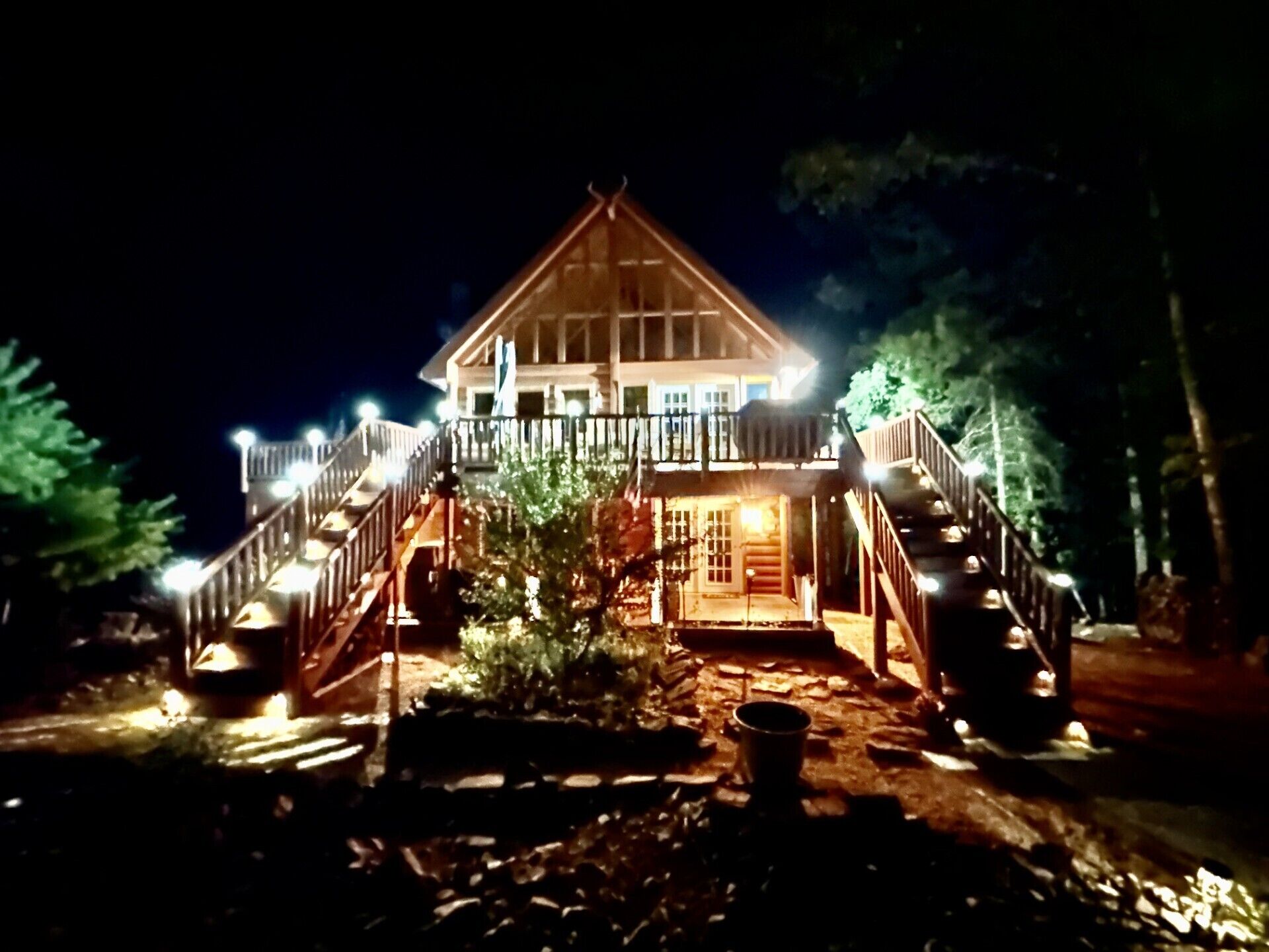 Eine zweistöckige Lodge mit einem Balkon und einer Treppe, die zum Eingang führt.