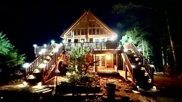 Eine zweistöckige Lodge mit einem Balkon und einer Treppe, die zum Eingang führt.