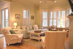 A living room with a sofa, chairs, a coffee table, and a fireplace.