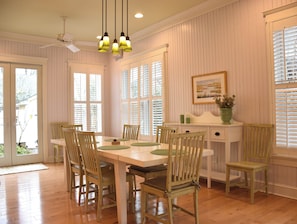 A dining room with a wooden table, chairs, and a ceiling fan.