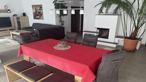 Una sala de estar moderna con comedor, chimenea y televisor.