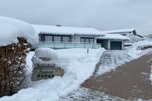 Edificio cubierto de nieve con un cartel que dice 'Ferienhaus Kranenet'.