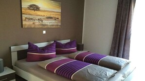 Una cama con cabecera, dos almohadas y una colcha.