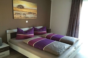 Een bed met hoofdbord, twee kussens en een dekbed.