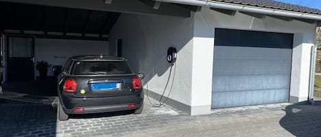 Een auto geparkeerd in een overdekte garage met een laadstation.