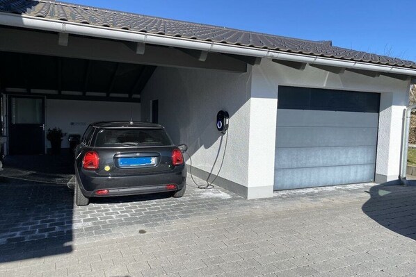 Un automóvil estacionado en un garaje cubierto con una estación de carga.
