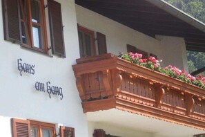 A building with a balcony adorned with flowers and a sign that reads 'Gams am Gang.' - Holiday apartment with 1 bedroom (Schönau am Königssee)