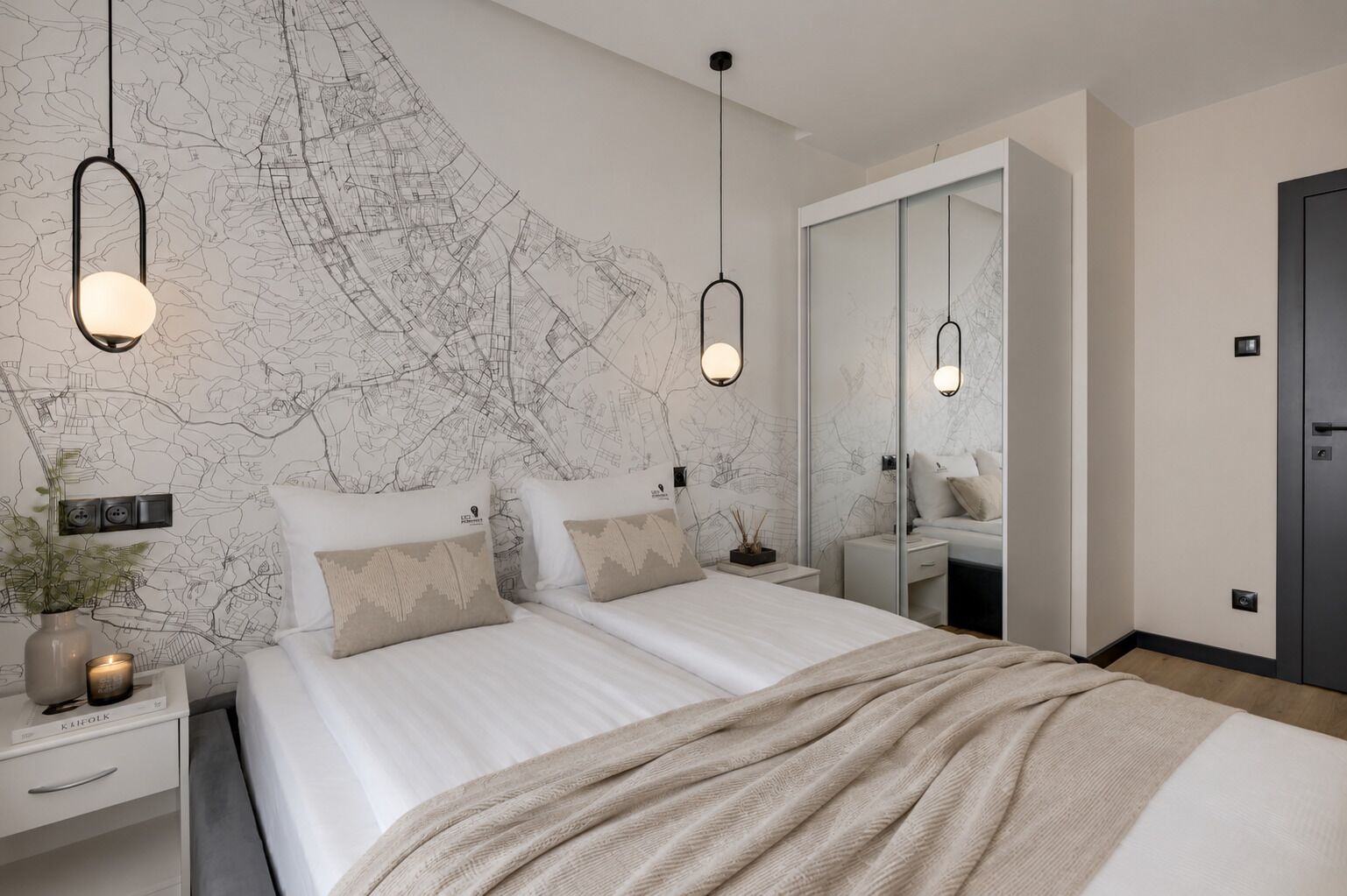 A modern bedroom with a large bed, bedside tables, a nightstand, a mirror, and a map on the wall.