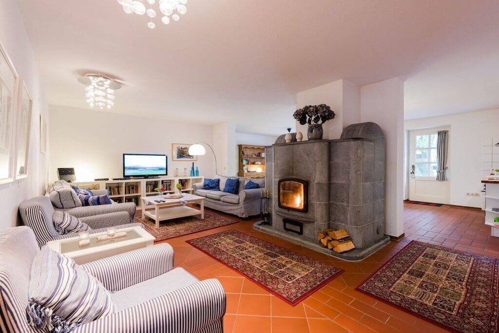 A living room with a fireplace, sofas, a television, and a bookshelf.