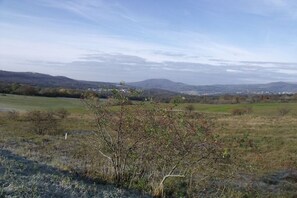 Paisatge rural amb turons suaus, cel serena i vegetació escassa.