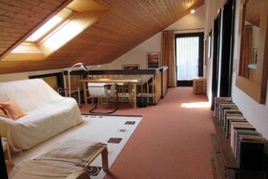 A cozy attic bedroom with a bunk bed, a desk, and a bookshelf.