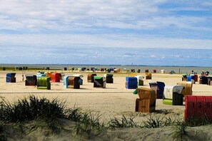Una spiaggia con numerose casette da spiaggia colorate.