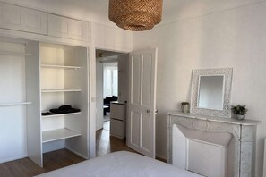 A room with a wardrobe, a mirror, and a fireplace. - Nice Apartment in Cherbourg for 4 Guests (Cherbourg-en-Cotentin)
