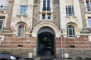 A multi-story building with a central archway entrance, stone facade, and multiple windows. - Nice Apartment in Cherbourg for 4 Guests (Cherbourg-en-Cotentin)
