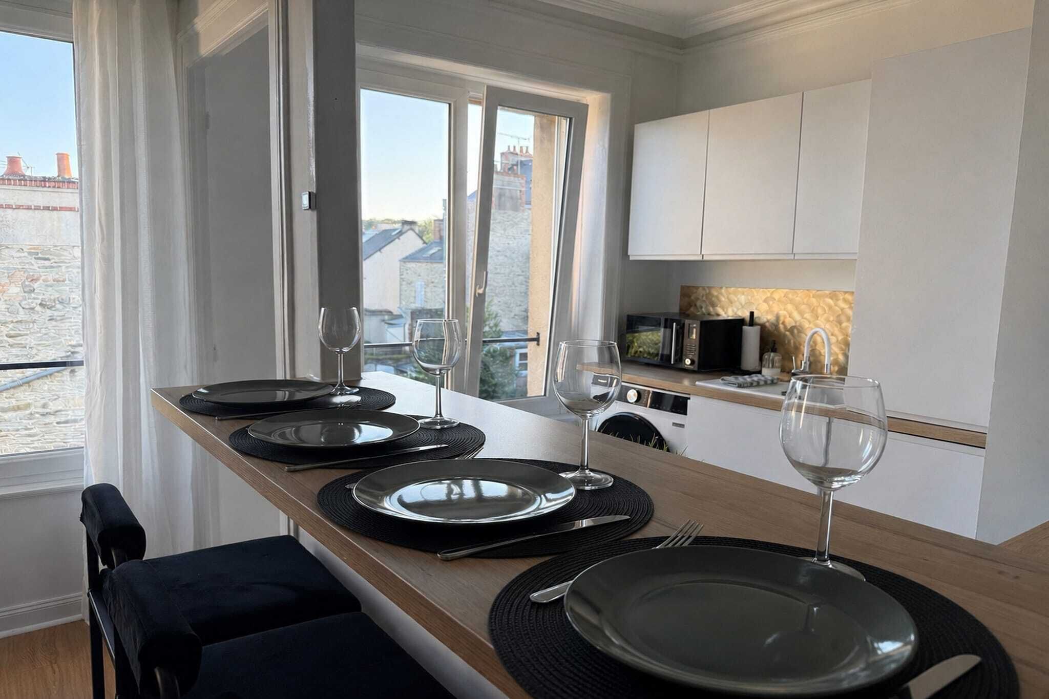 Una cocina moderna con comedor, equipada con microondas, pileta y vistas al exterior.
