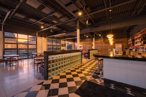 A bar area with checkered flooring, a bar counter, and seating arrangements. - 4BR 3BA KC Loft Collection Rooftop Bar Spa (Kansas City)