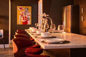 A modern kitchen with a marble countertop, a built-in oven, and a refrigerator. - 4BR 3BA KC Loft Collection Rooftop Bar Spa (Kansas City)