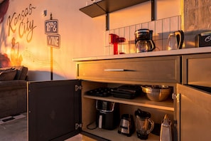 A kitchenette with a coffee maker, kettle, and various kitchen utensils. - 4BR 3BA KC Loft Collection Rooftop Bar Spa (Kansas City)