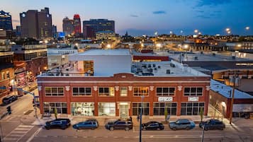 A multi-story building with a prominent 'OPS KC' sign, surrounded by parked cars and a street view.