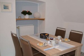 Een ontbijtruimte met een gedekte tafel, inclusief brood, eieren en een koffiekop.