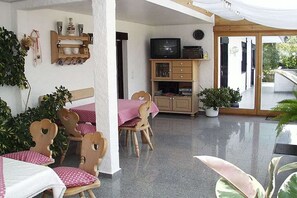 A room with a dining table and chairs, a television, and a cabinet. - on the Schmöllerhof grounds (Jandelsbrunn)