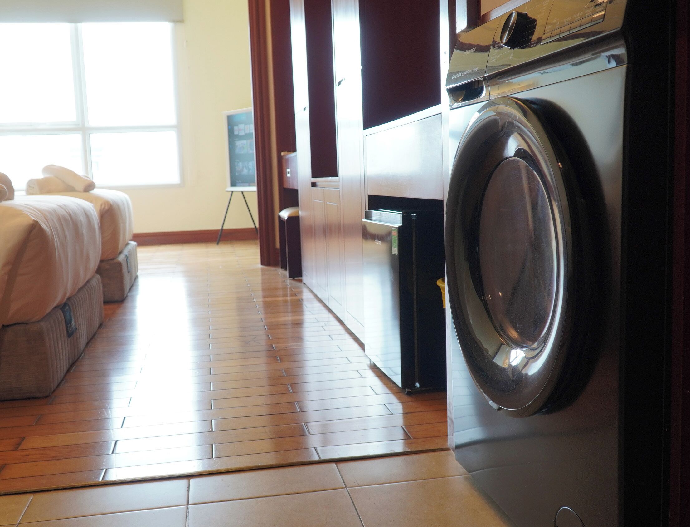 Une buanderie équipée d’un lave-linge, d’un étendoir et d’une petite table avec une chaise.