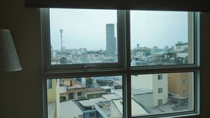A multi-pane window with a view of a cityscape, including buildings and a tower. - The Manor 2 (Thanh My Tay)