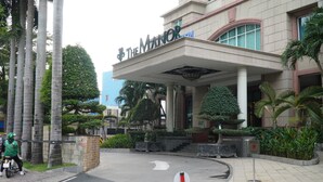 A hotel entrance with a sign reading 'The Manor.' - The Manor 2 (Thanh My Tay)