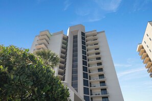 A multi-story building with balconies, surrounded by greenery. - Phoenix East II 2091 by Liquid Life (Orange Beach)
