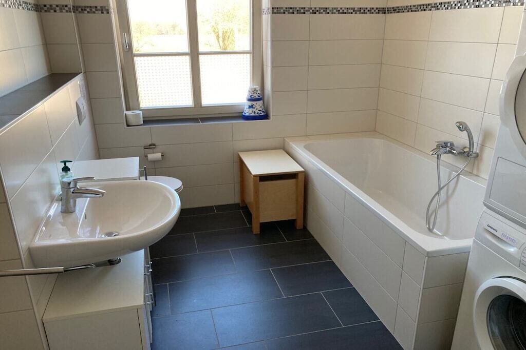 Een badkamer met een wastafel, toilet en bad.