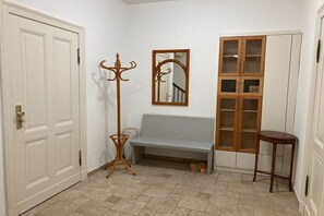 A hallway with a bench, a coat stand, a mirror, and a cabinet. - Holiday apartment in the yellow house (Karstädt)