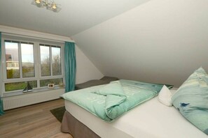 A bedroom with a bed, a window, and a radiator. - Knutt in the house Bill15 (Juist)
