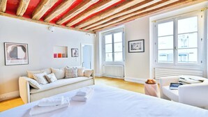 A hotel room with a bed, a sofa, a small table, and a window. - AN EXCELLENT COMBINATION OF PARISIAN CHARM & CENTRAL CONVENIENCE - SAINT GERMAIN (Paris)